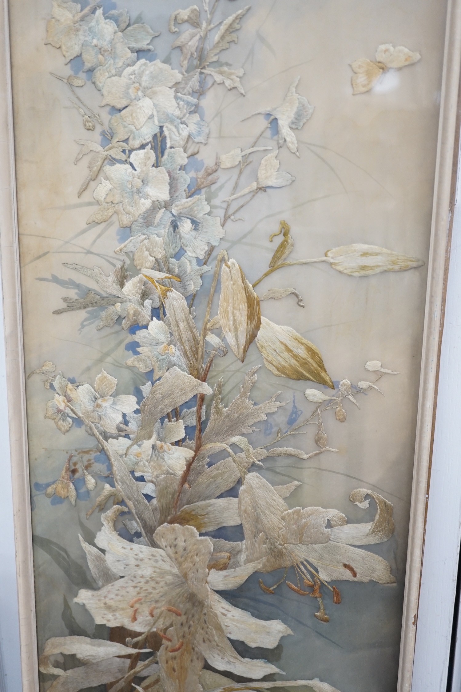 A framed silk embroidered panel, possibly French, cut from a larger piece, 137cms high x 27wide